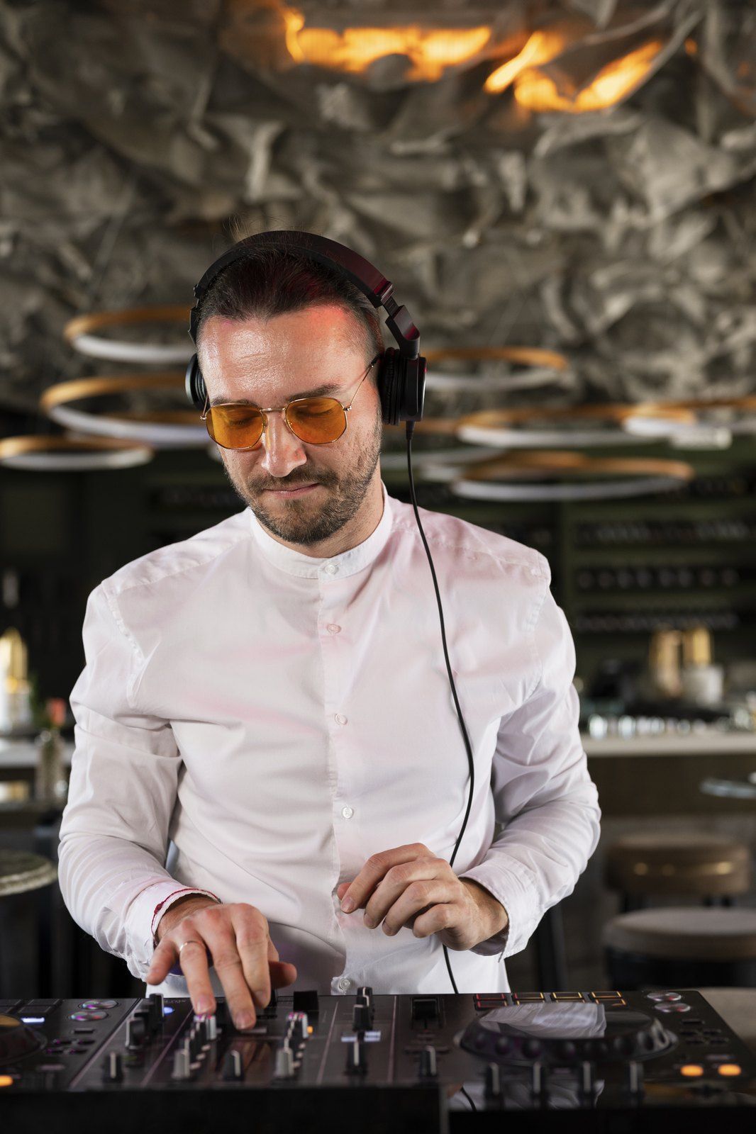 DJ με ακουστικά δουλεύει στην κονσόλα του σε πάρτι